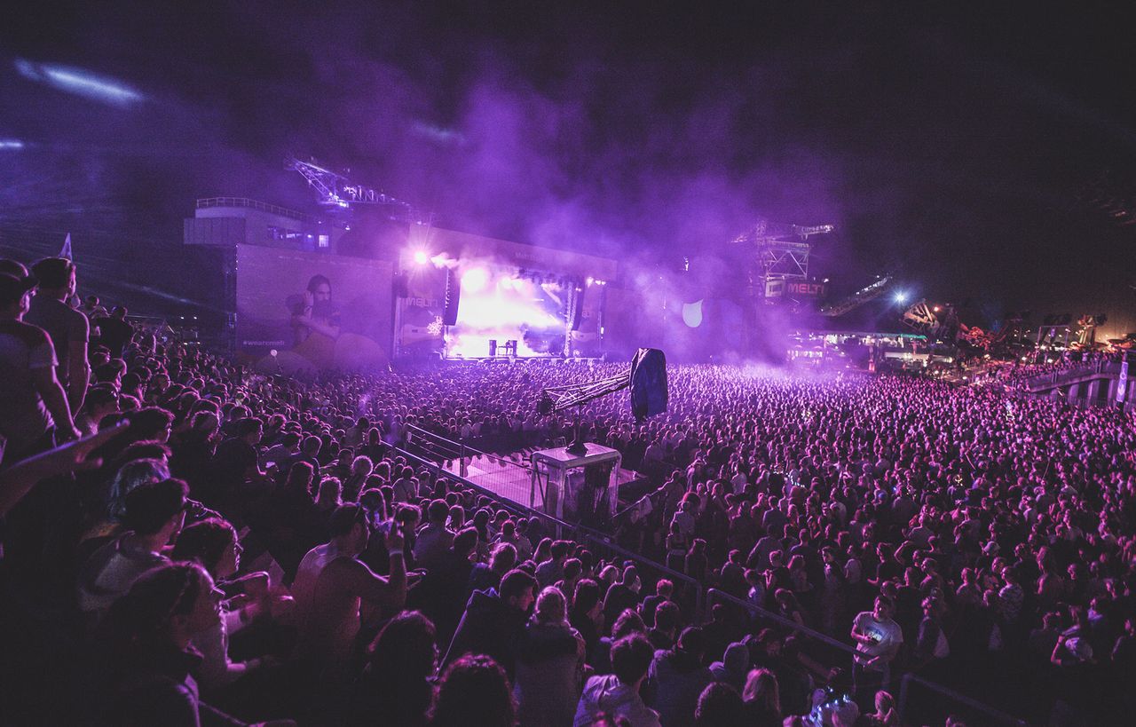 Volle Konzerthalle in violettem Licht